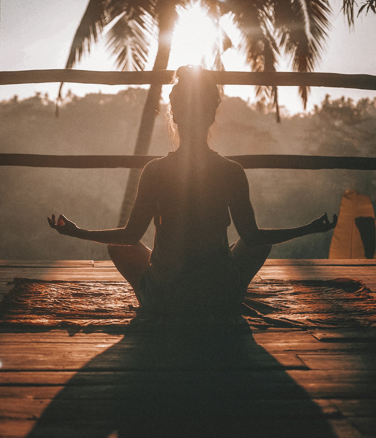 Person meditating at sunrise for mental strength